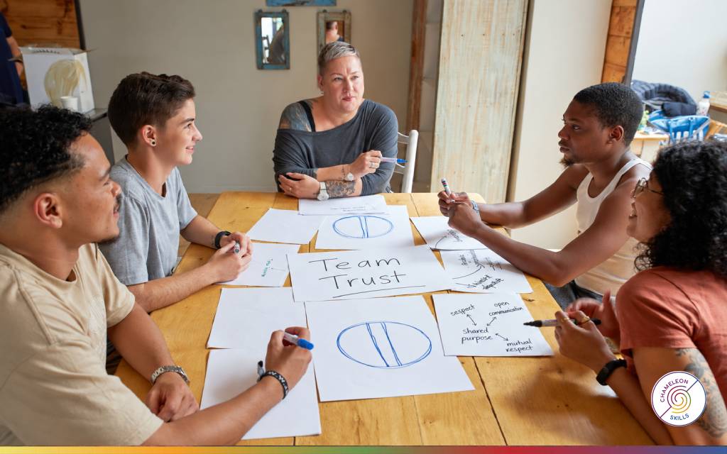 Diverse team having an open discussion around a table, representing trust, shared purpose and strong workplace relationships.